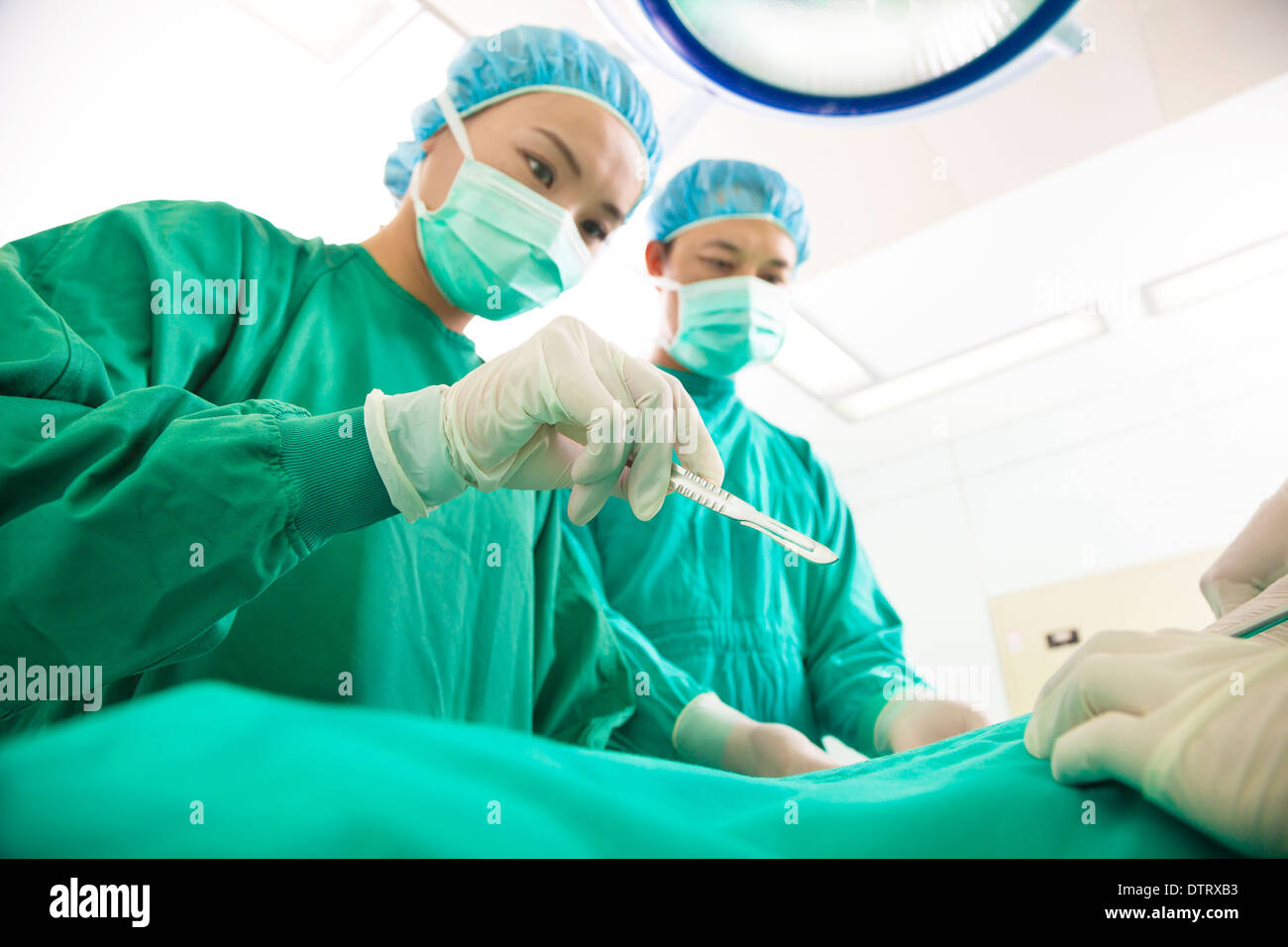 Professional aesthetic medicine surgeon operating  with scalpel at hospital Stock Photo