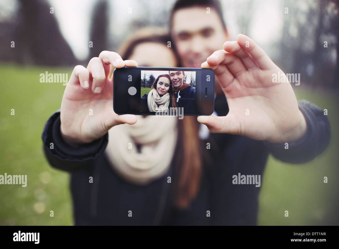 Mixed race young boy and girl making a funny face while taking a self portrait with mobile phone. Cute young couple. Stock Photo