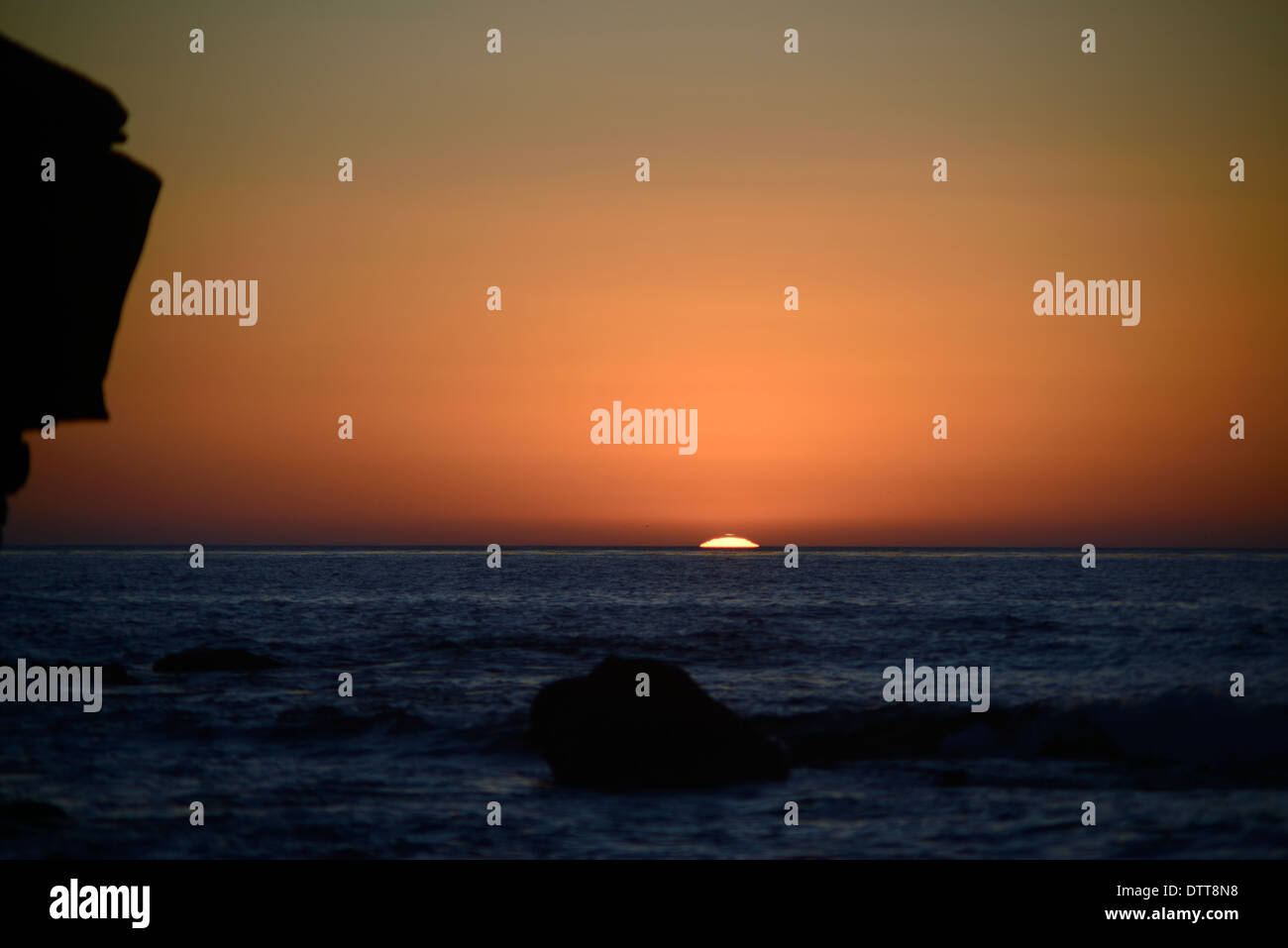 A mock-mirage green flash appears above the sun at sunset in San Diego, California. © Craig M. Eisenberg Stock Photo