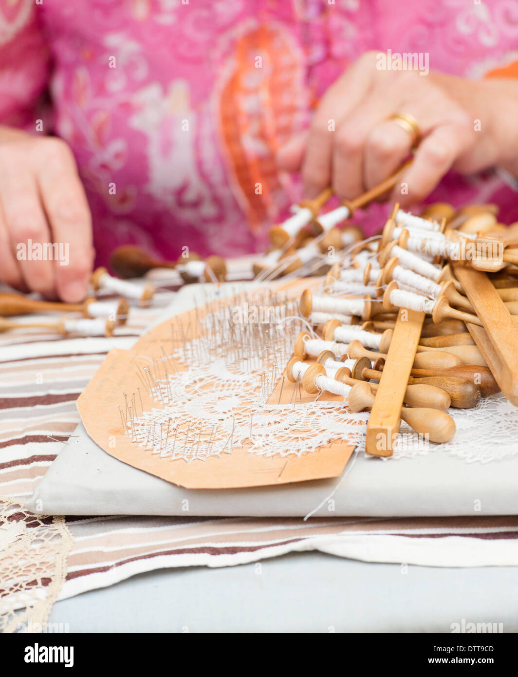 Close up of lacemaking artisan, an elderly woman working on a lace pattern. Stock Photo