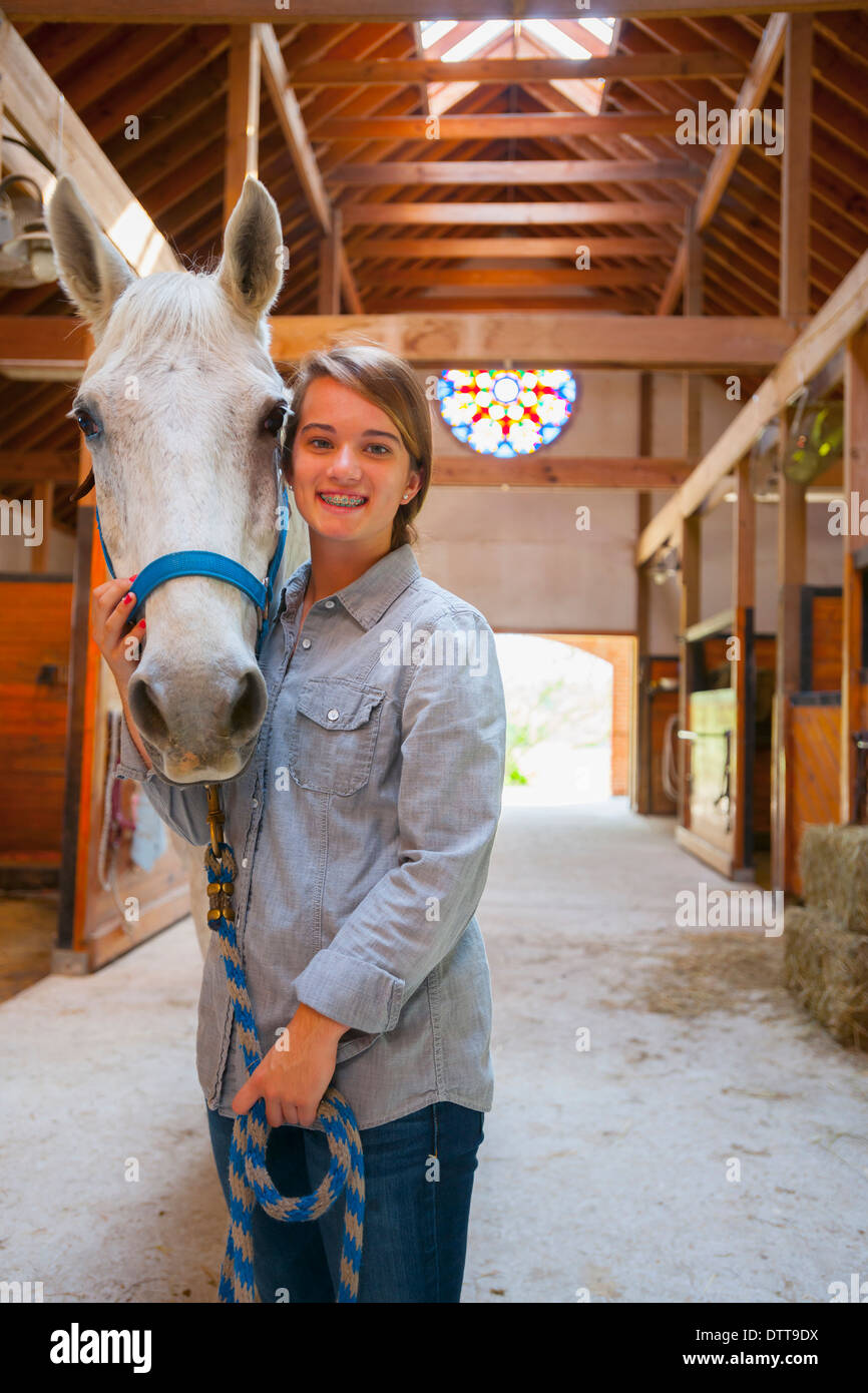 Caucasian girl smiling with horse in stable Stock Photo - Alamy