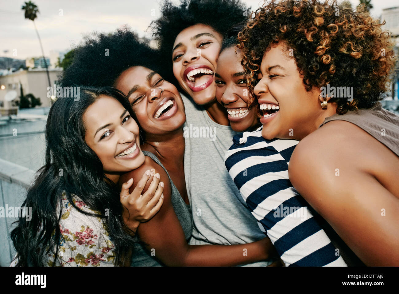 Women laughing together on urban rooftop Stock Photo