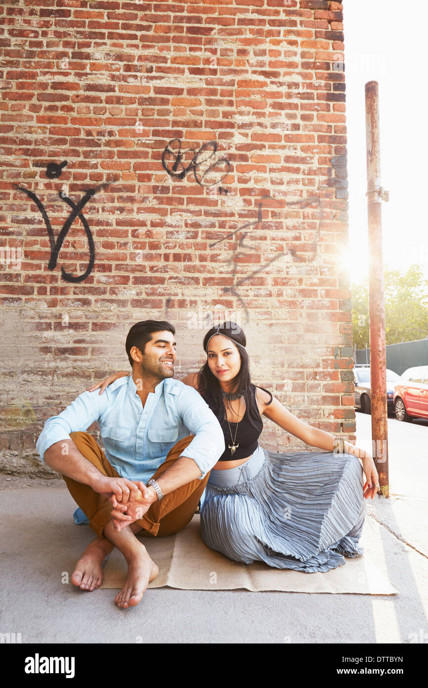 Indian couple sitting on city street Stock Photo
