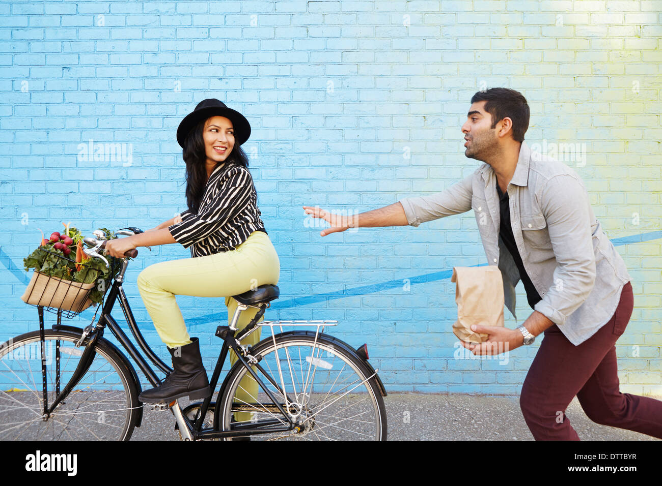 Indian man chasing girlfriend on bicycle Stock Photo