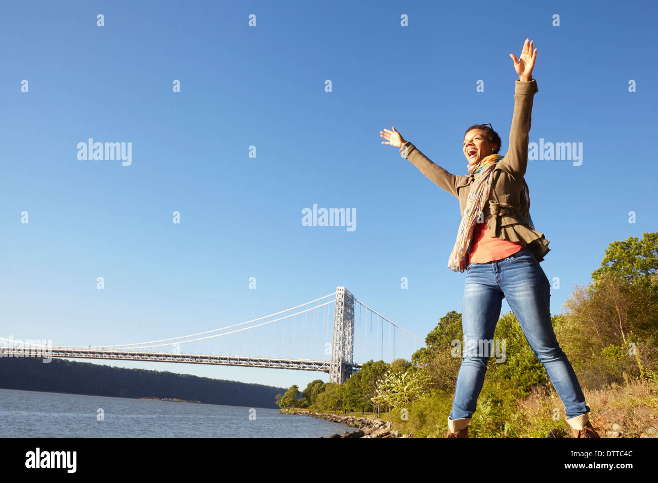 Black woman cheering by river Stock Photo