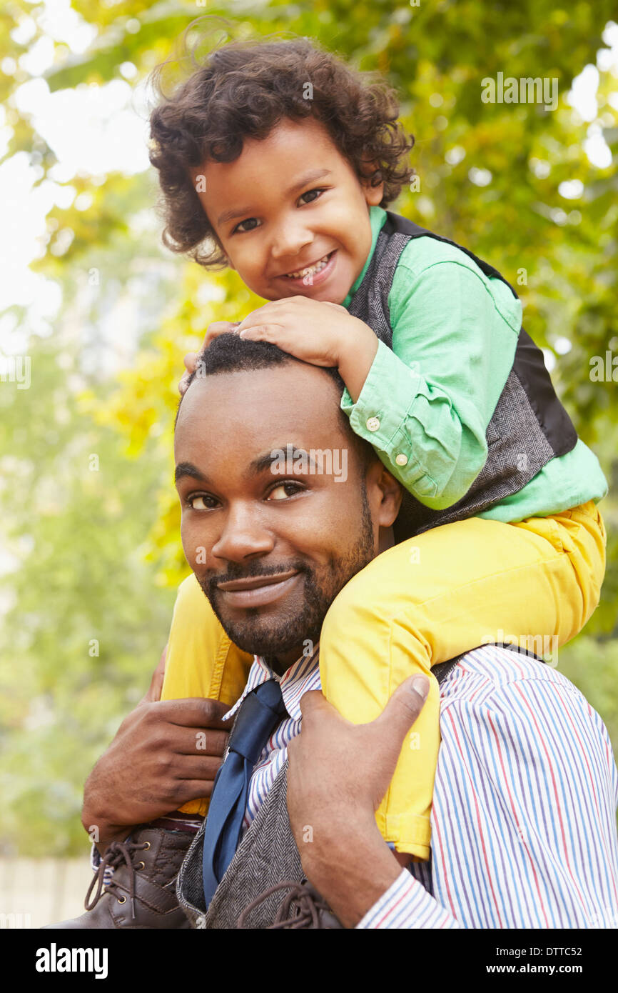 Father carrying son in park Stock Photo