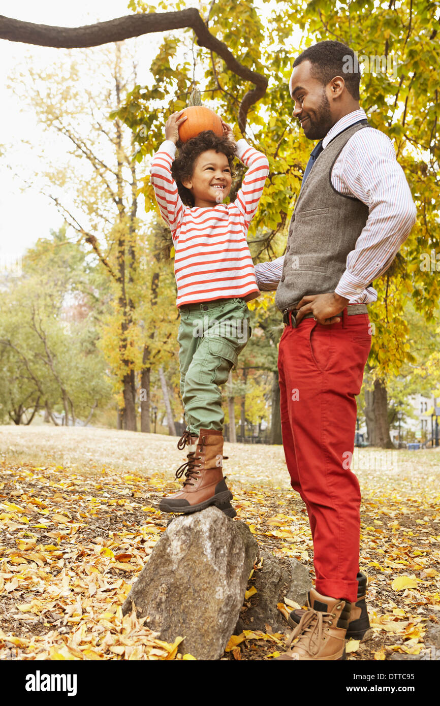 Father and son holding pumpkin in park Stock Photo