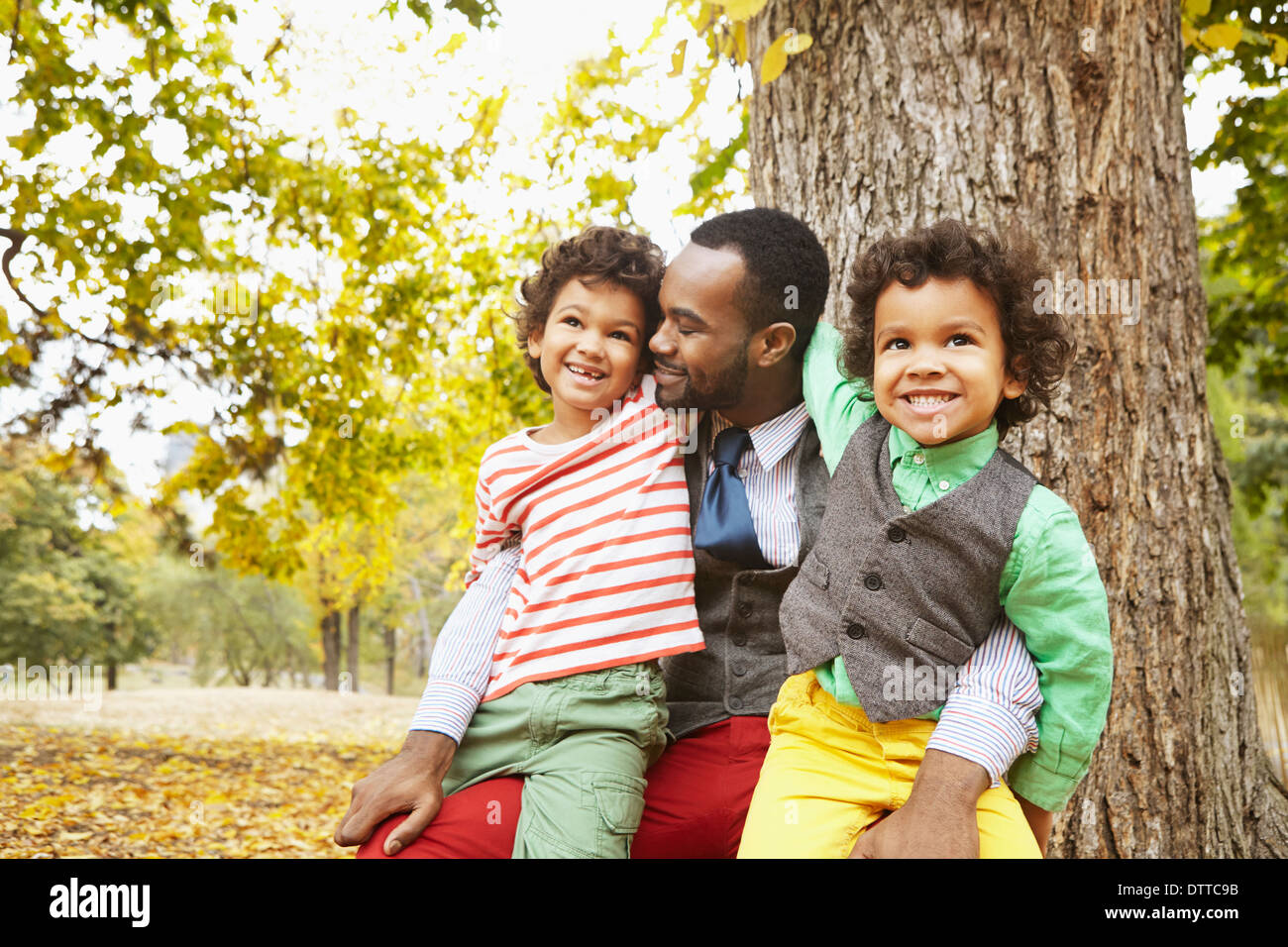Father and sons smiling in park Stock Photo