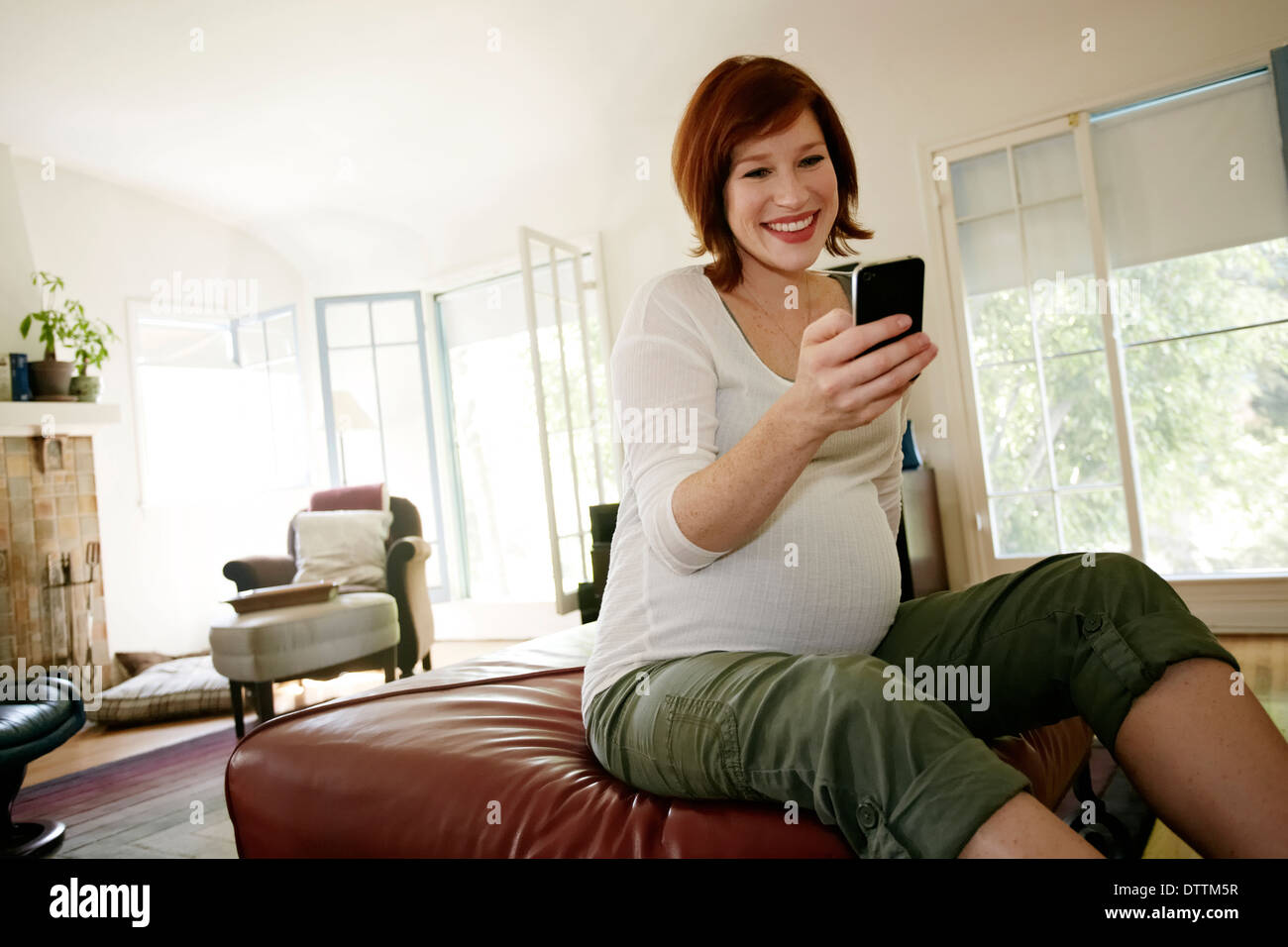 Pregnant Caucasian woman using cell phone Stock Photo