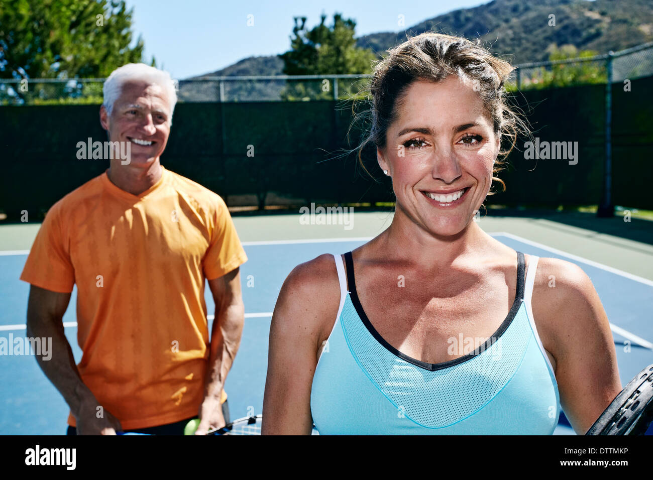 Caucasian couple standing on tennis court Stock Photo