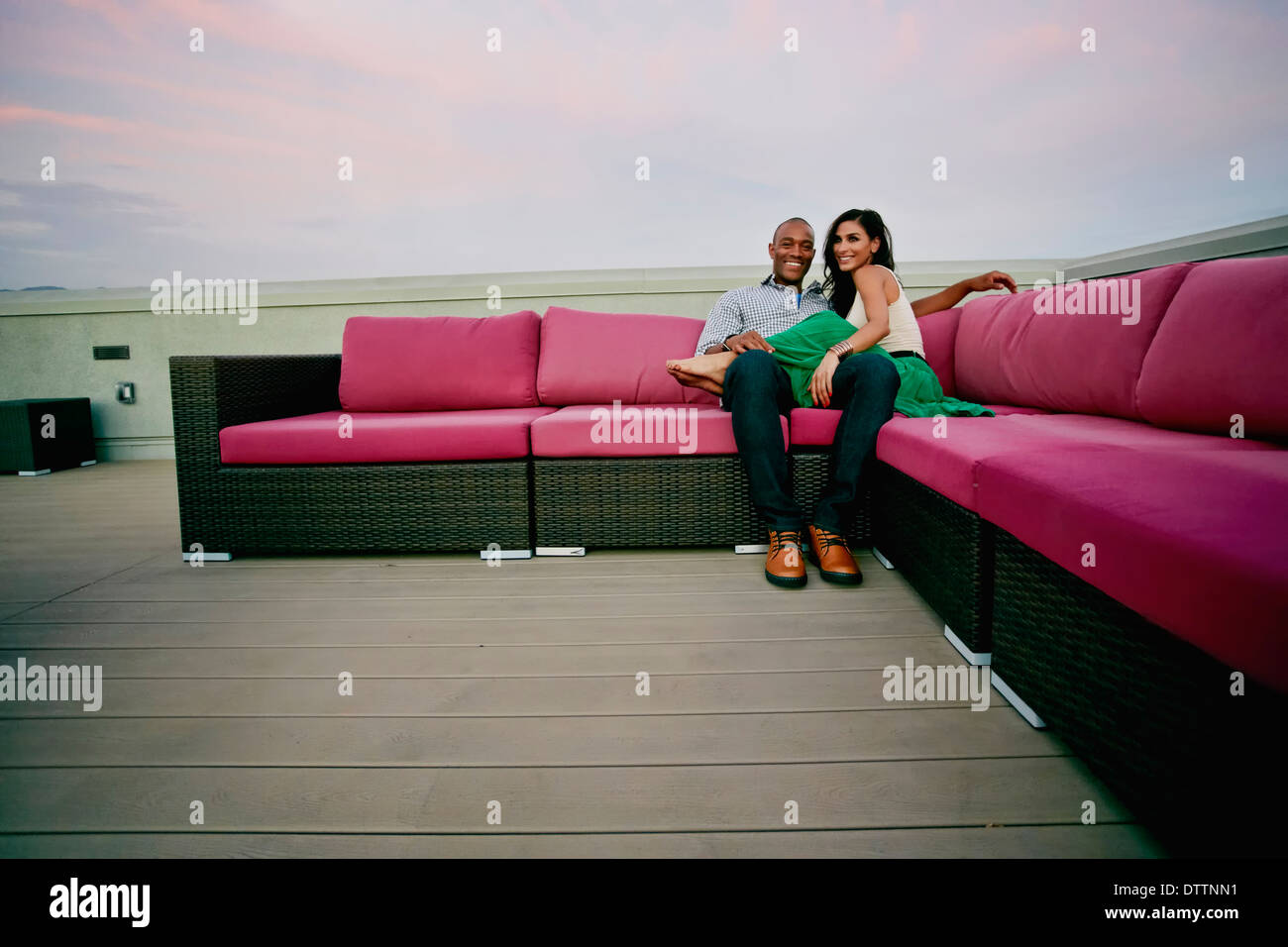 Couple relaxing on sofa outdoors Stock Photo