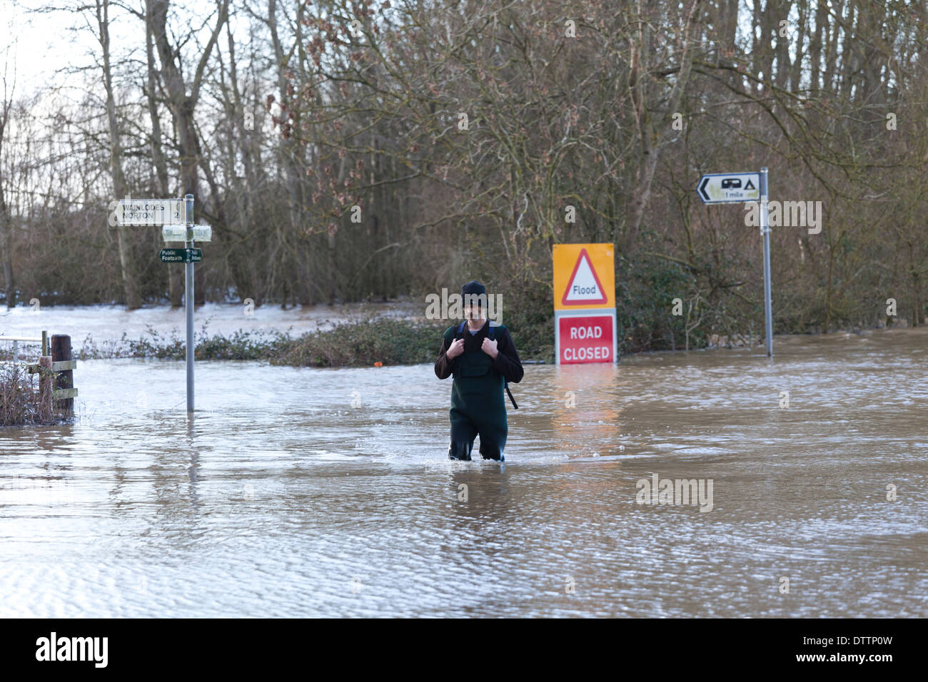Ex-soldier walking through floodwaters at Apperley, Gloucestershire UK to deliver supplies and medication to a sick friend. Stock Photo