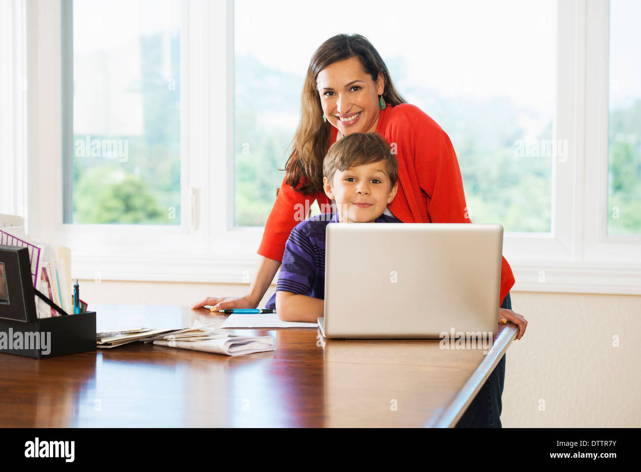 Mother and son using laptop together Stock Photo