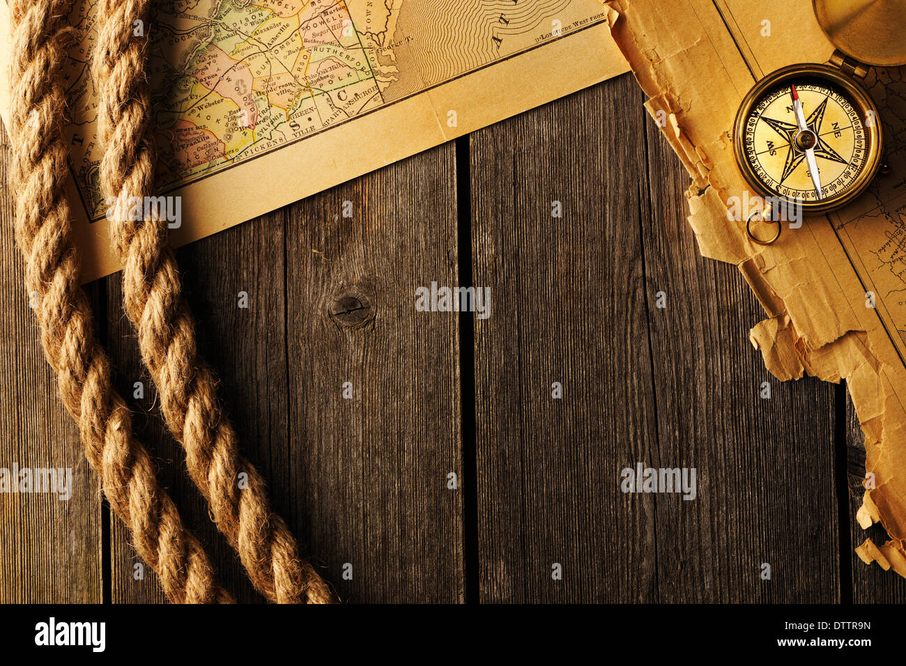 Antique compass and rope over old map Stock Photo - Alamy