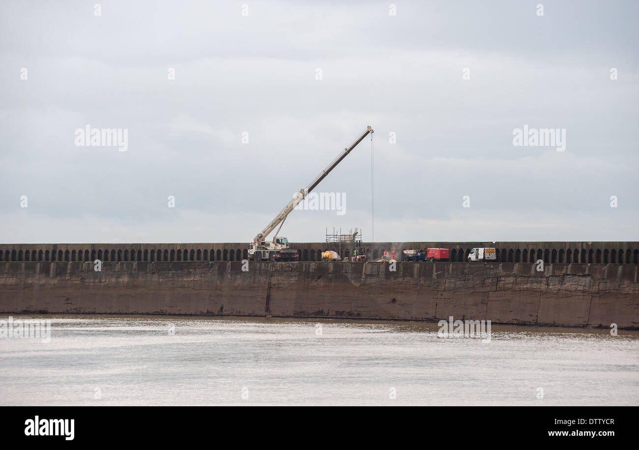 Work goes on to repair the sea wall at Newhaven after bad weather caused major damage Stock Photo