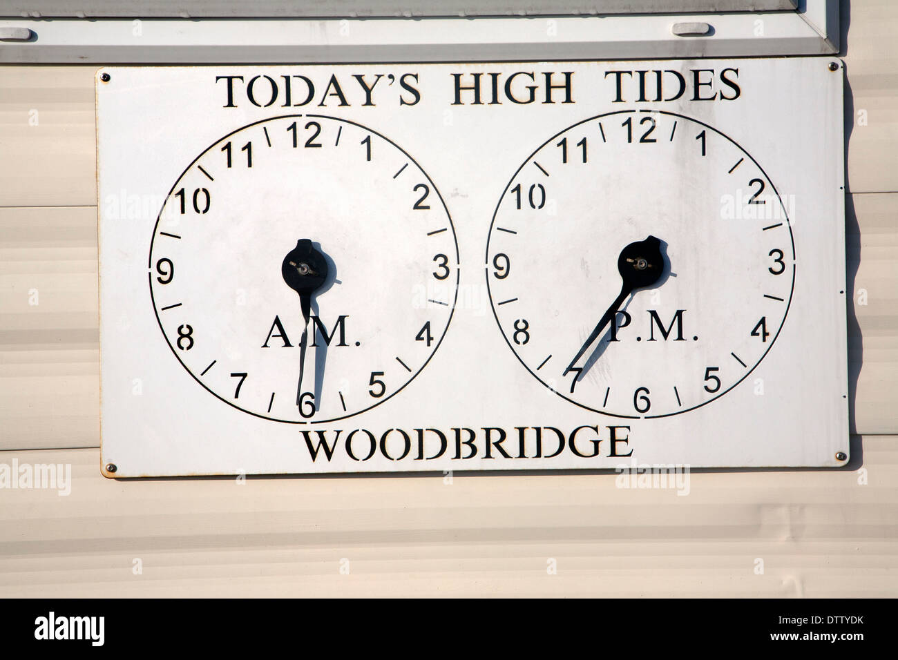 Two clocks showing times of high tides at Woodbridge, Suffolk, England Stock Photo