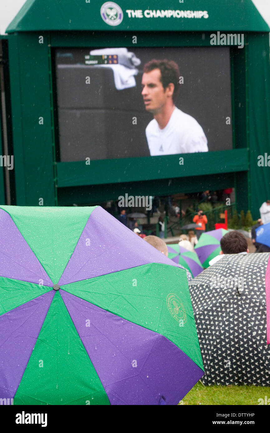 Murray mount, in background a TV screen showing Andy Murray foreground open Wimbledon umbrella Stock Photo