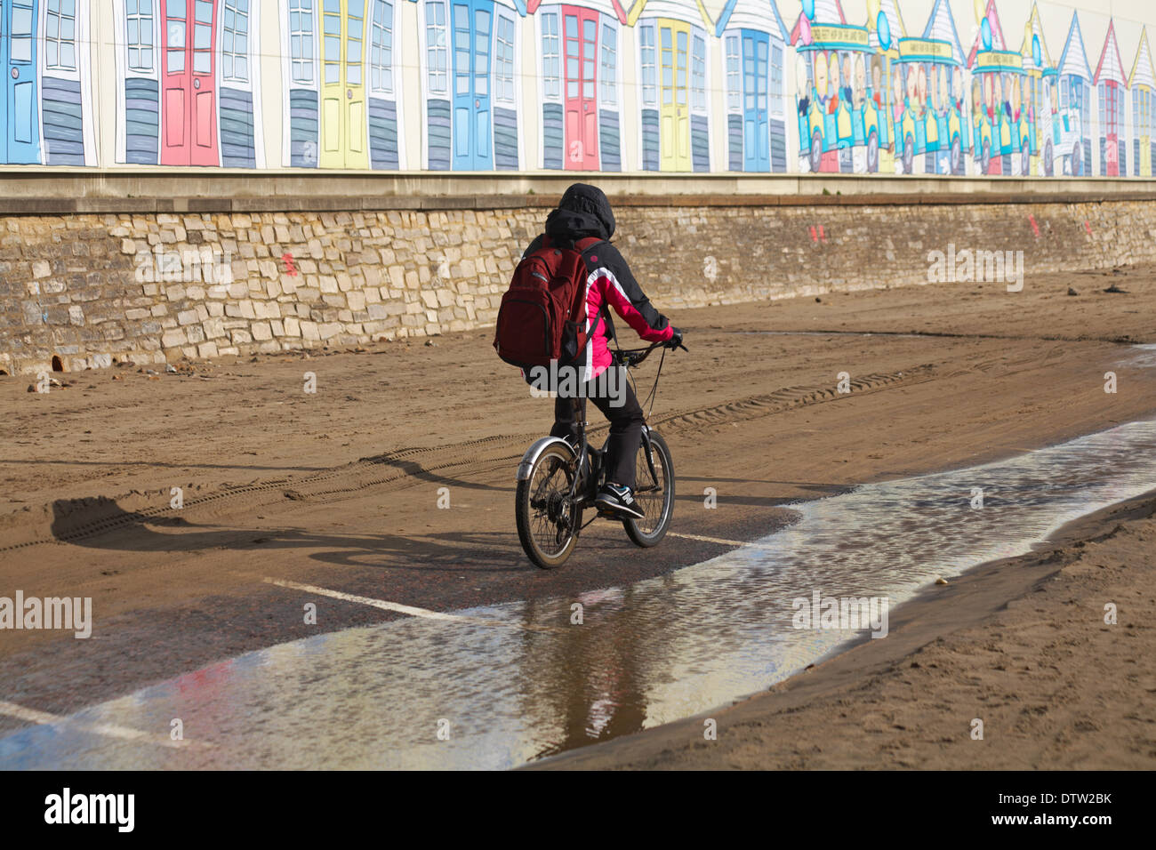 riding along Bournemouth seafront on a bike past painting of the beach ...