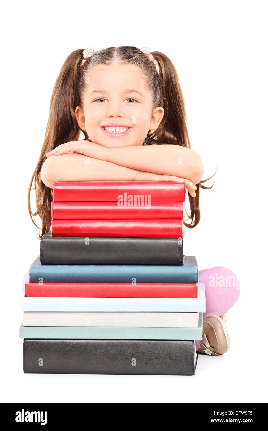 Little girl sitting on the floor behind a stack of books Stock Photo ...