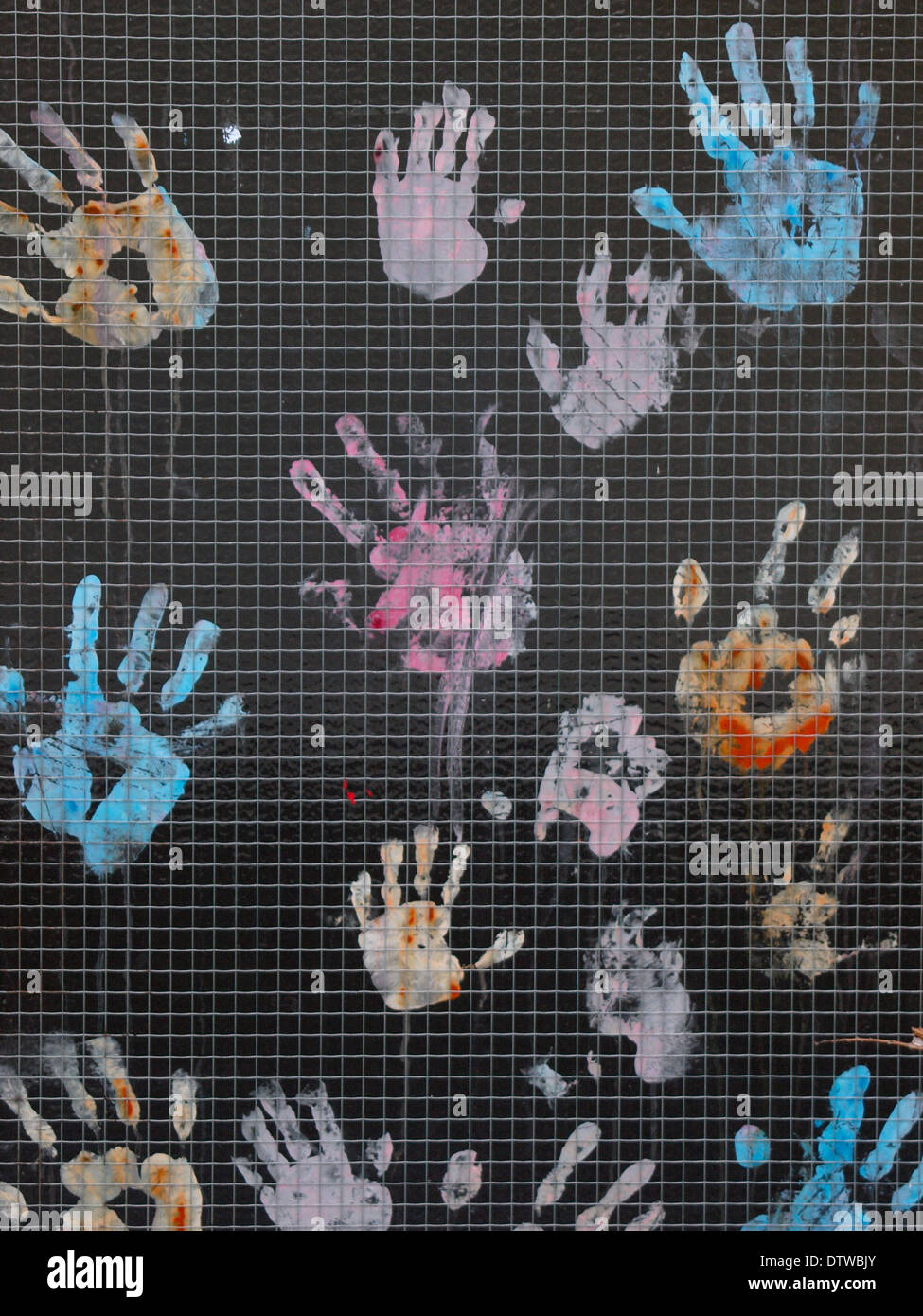 Painted hand prints on the glass of door of primary school, Bude, Cornwall, UK Stock Photo
