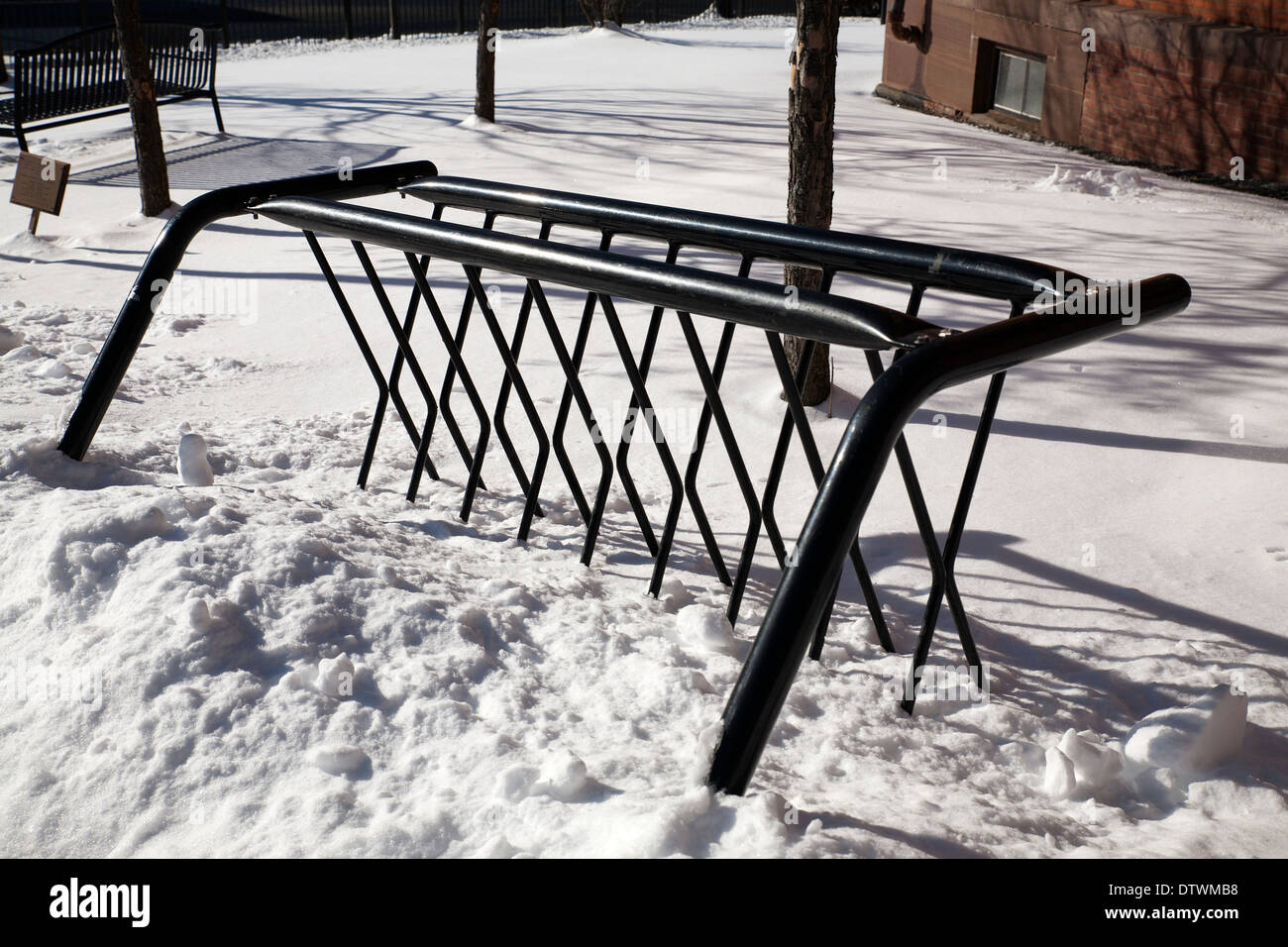 a bicycle rack sits unused in the deep winter snow in New England. Stock Photo