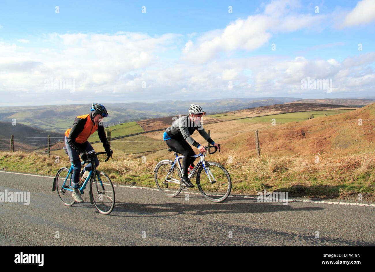 Male cyclists ride up Ringinglow Road near Sheffield & Hathersage in the Peak District National Park, Derbyshire, England, UK Stock Photo