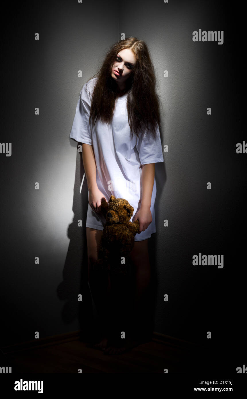 Zombie girl with teddy bear on black Stock Photo