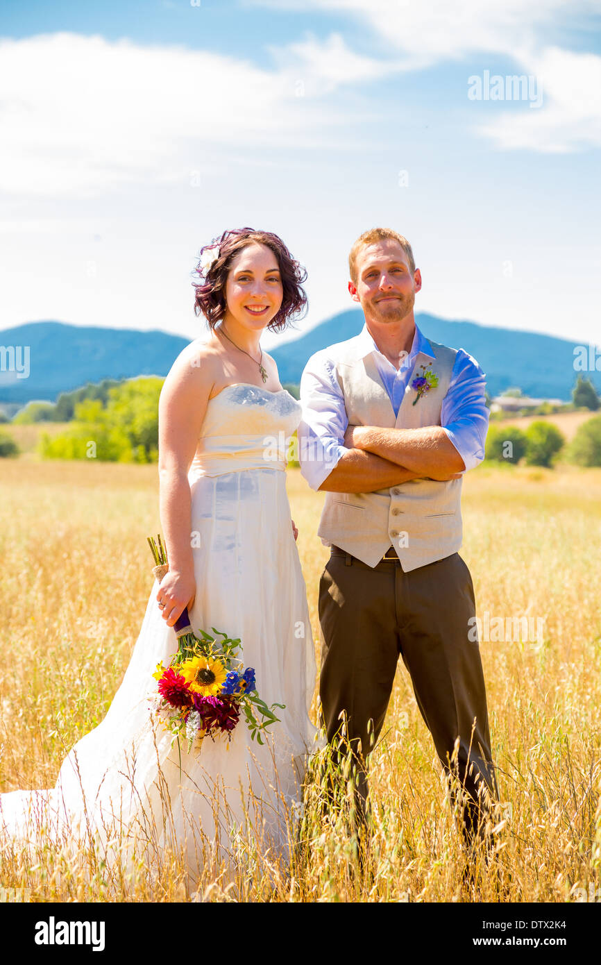 Bride And Groom Walking Together On Their Wedding Day Through A Field bride-and-groom-walking-together-on-their-wedding-day-through-a-field