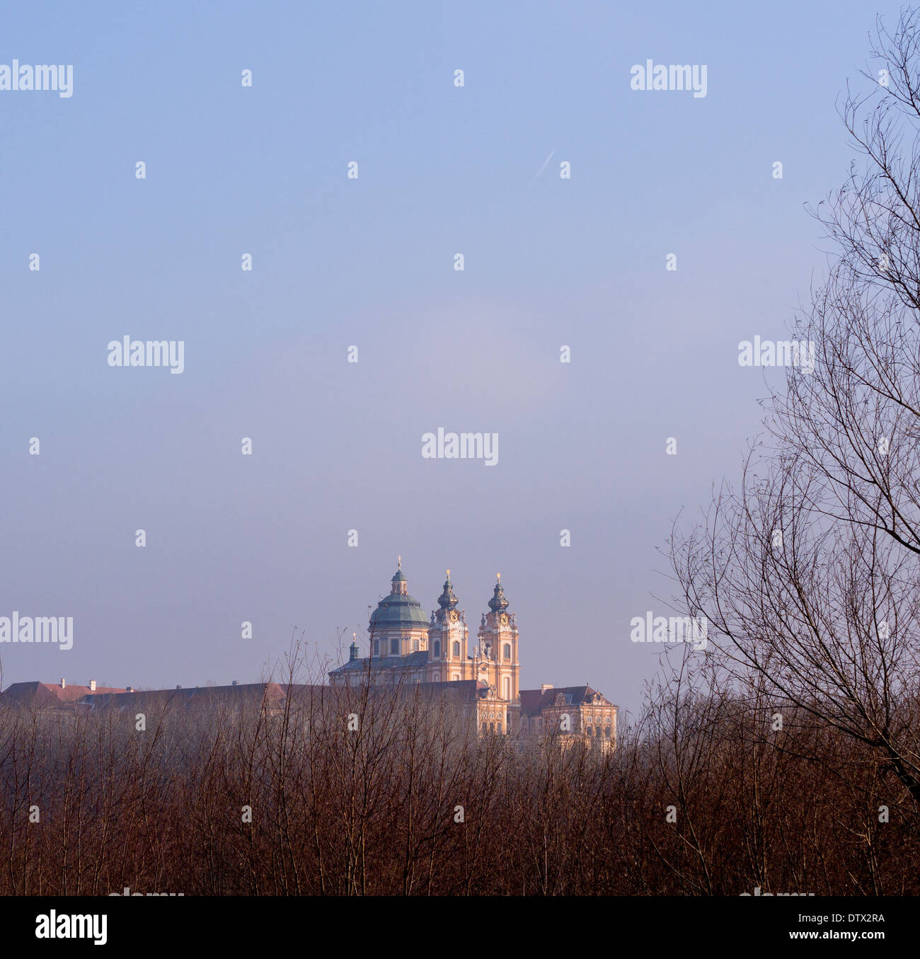Melk Abbey monastery among the trees. Atop a high cliff the massive abbey floats above the trees that line the Danube River. Stock Photo