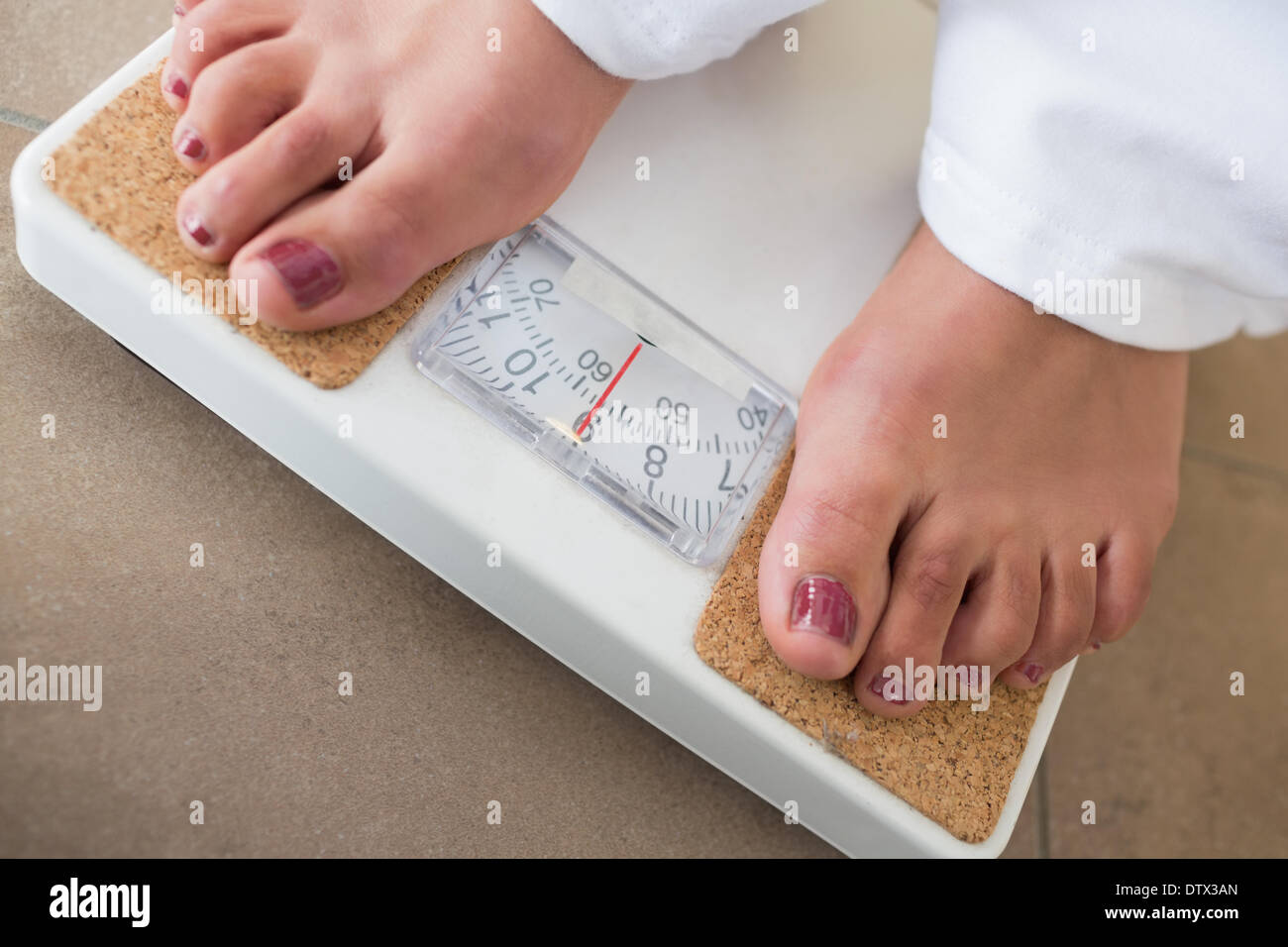 Womans feet on scales Stock Photo Alamy