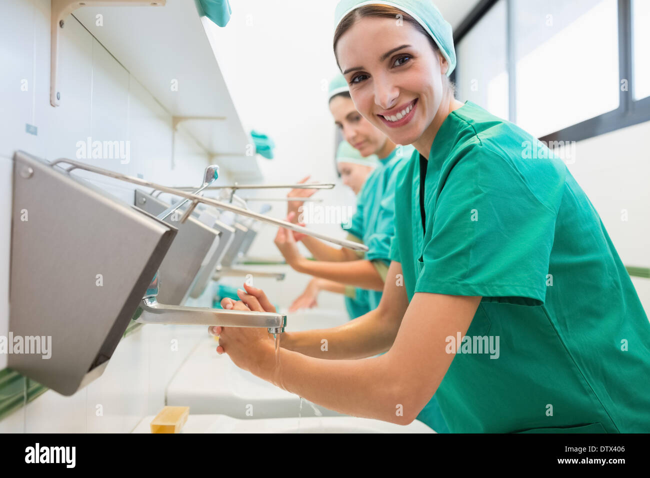 Surgeons washing their hands while smiling Stock Photo Alamy
