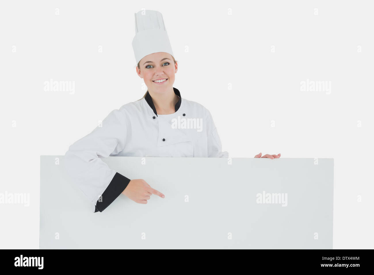 Happy female chef pointing at billboard Stock Photo Alamy