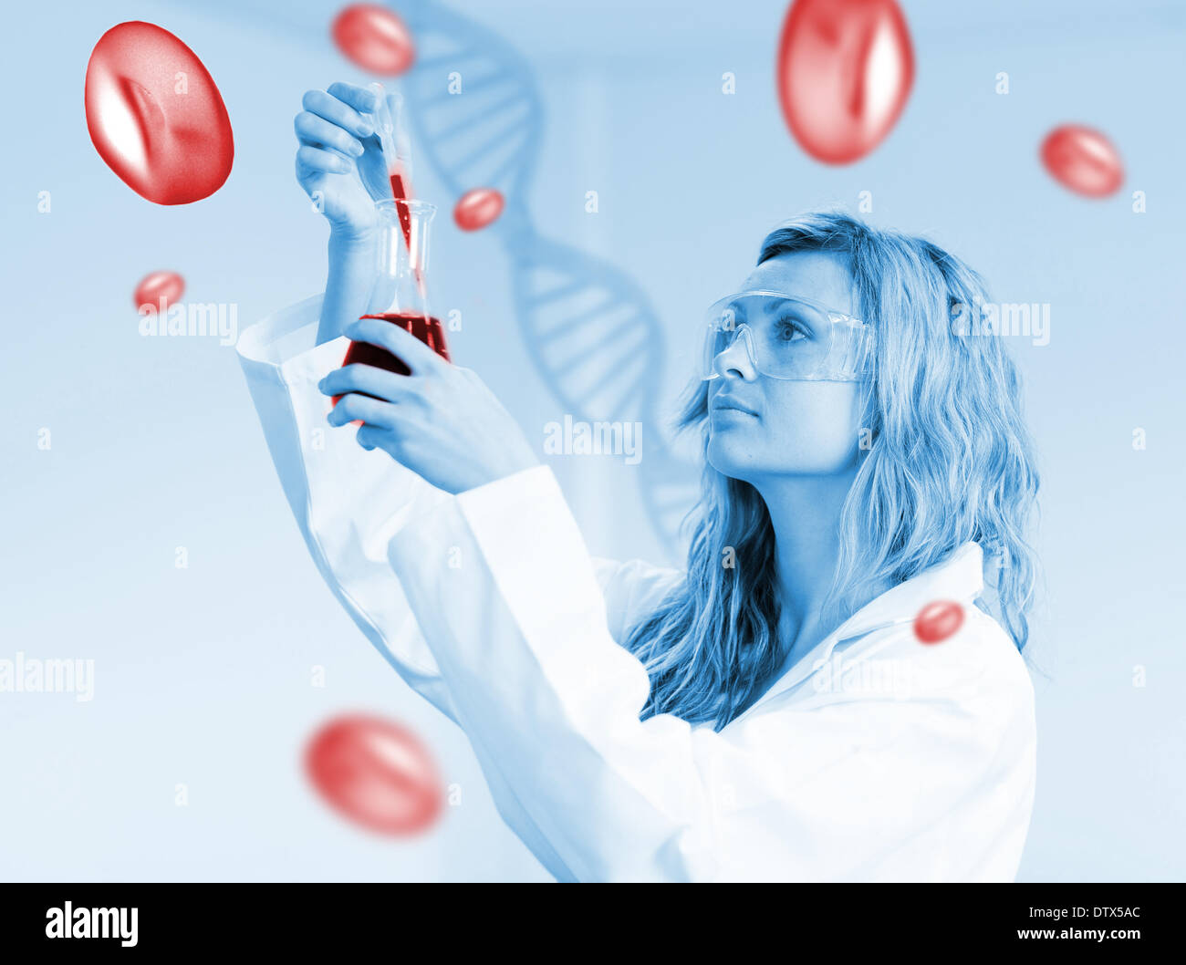 Woman in labcoat looking at beaker of blood Stock Photo