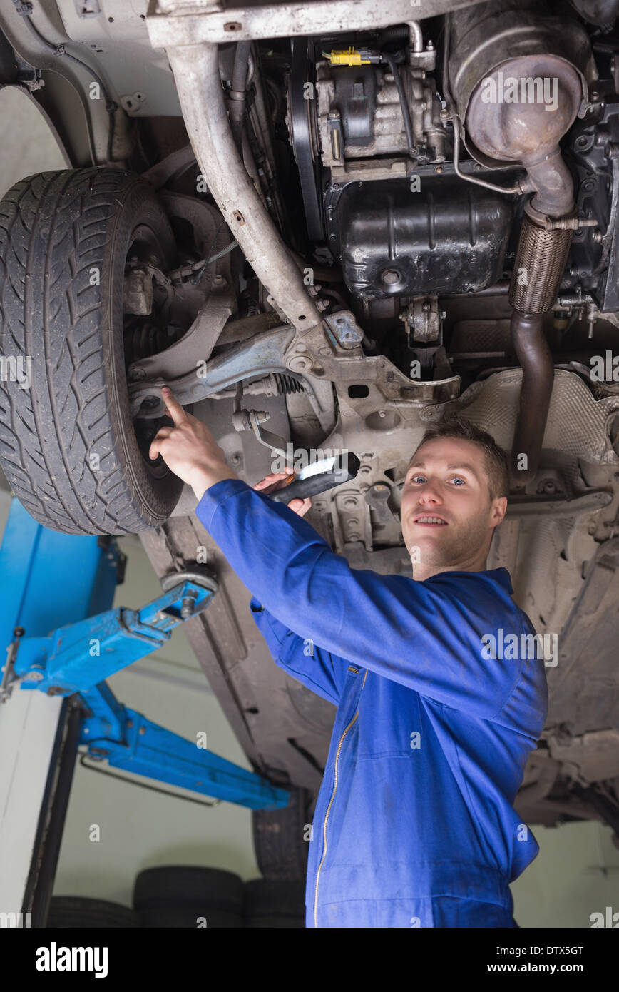 Male mechanic examining under vehicle Stock Photo - Alamy