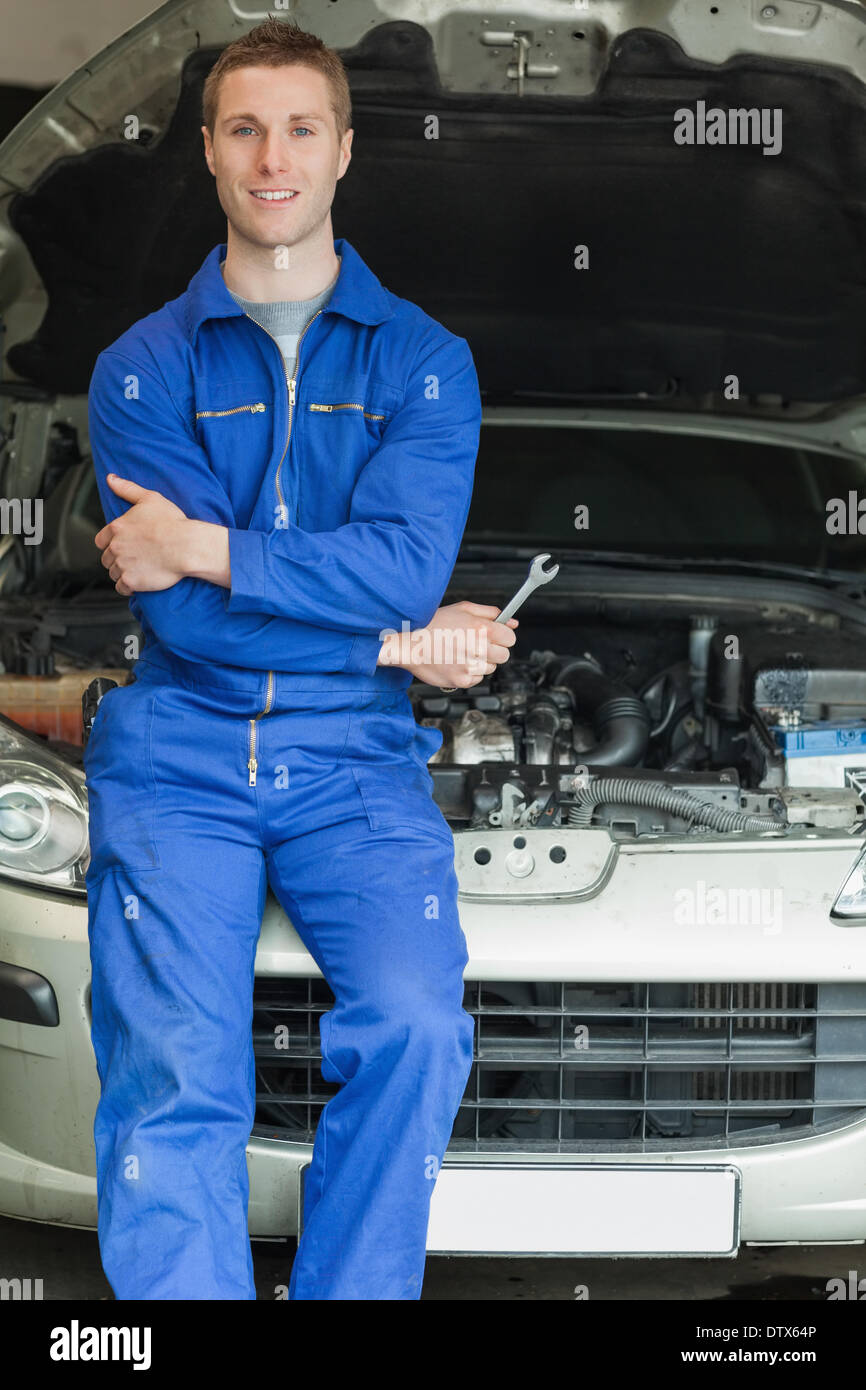 Happy mechanic leaning on breakdown car Stock Photo Alamy