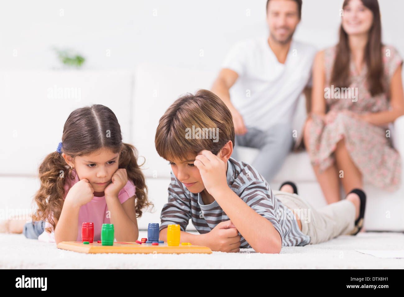 Siblings playing board game on the floor Stock Photo Alamy