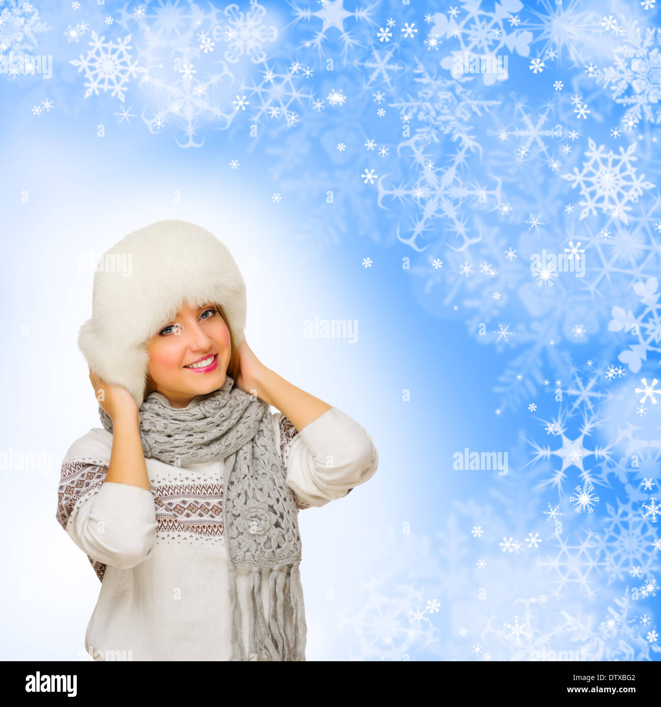 Young girl in fur hat on winter background Stock Photo