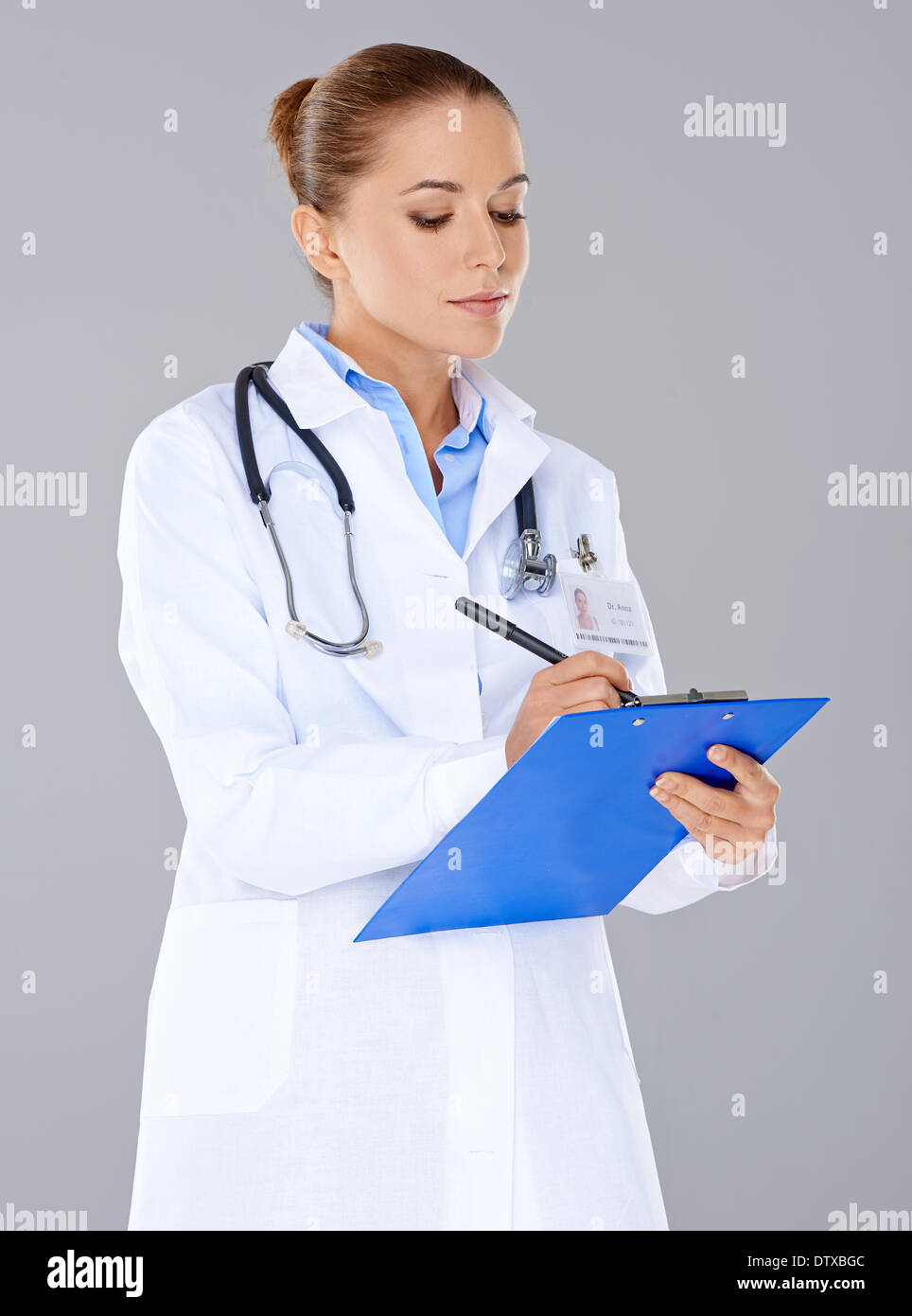 Doctor writing on a patients file Stock Photo