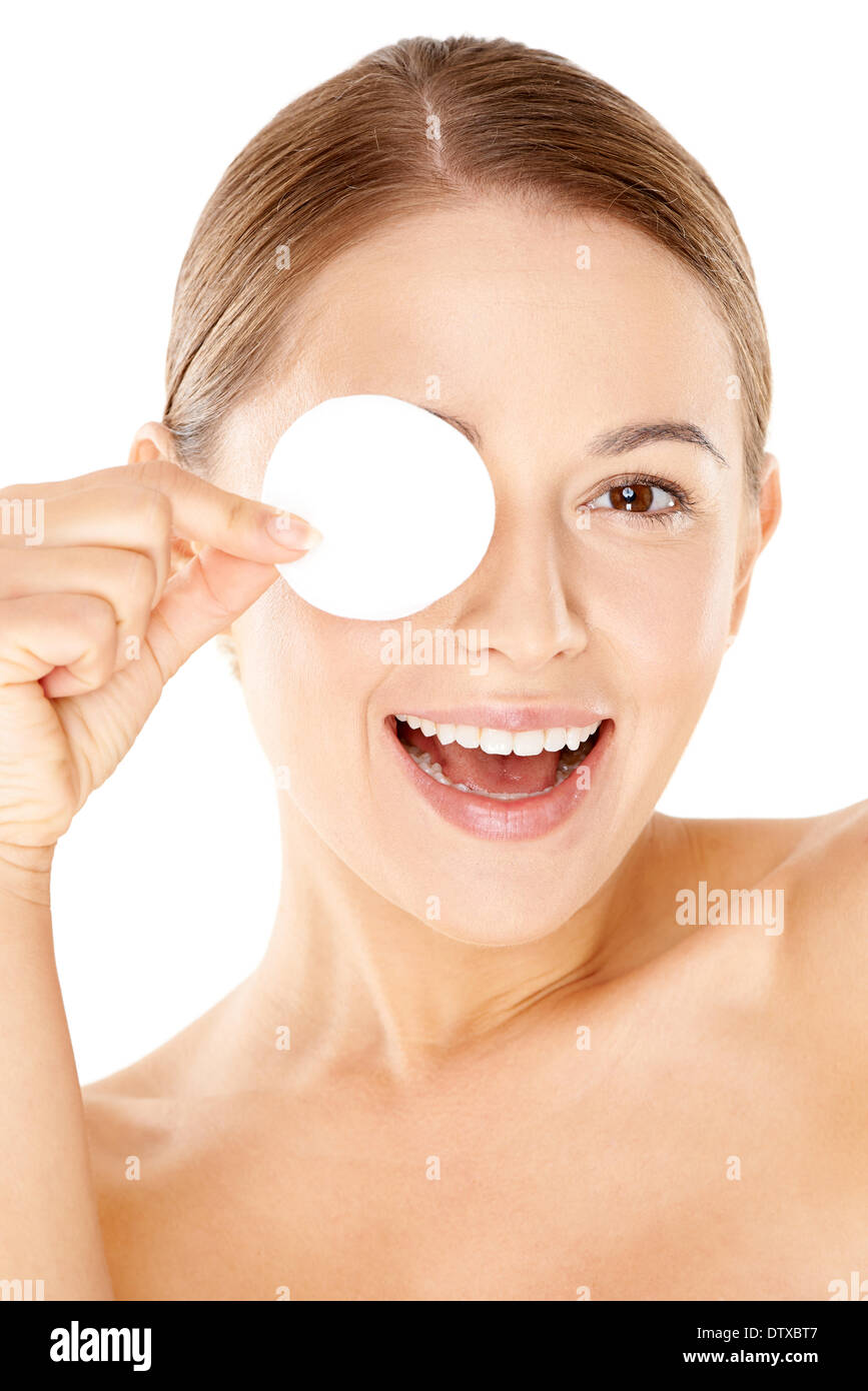 Laughing woman holding a cotton pad to her eye Stock Photo