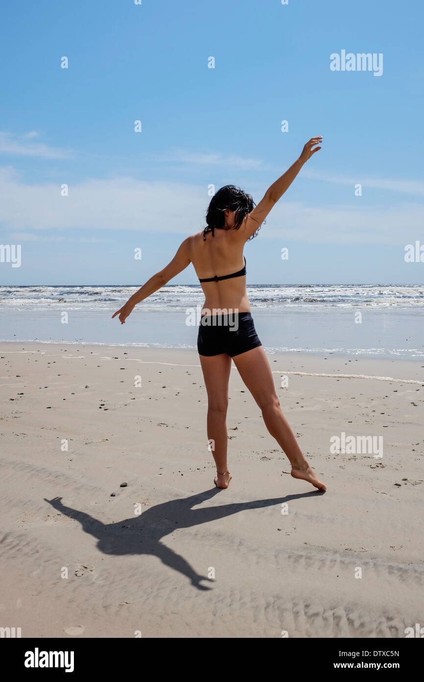 A healthy young teenager cartwheeling on a beach Stock Photo