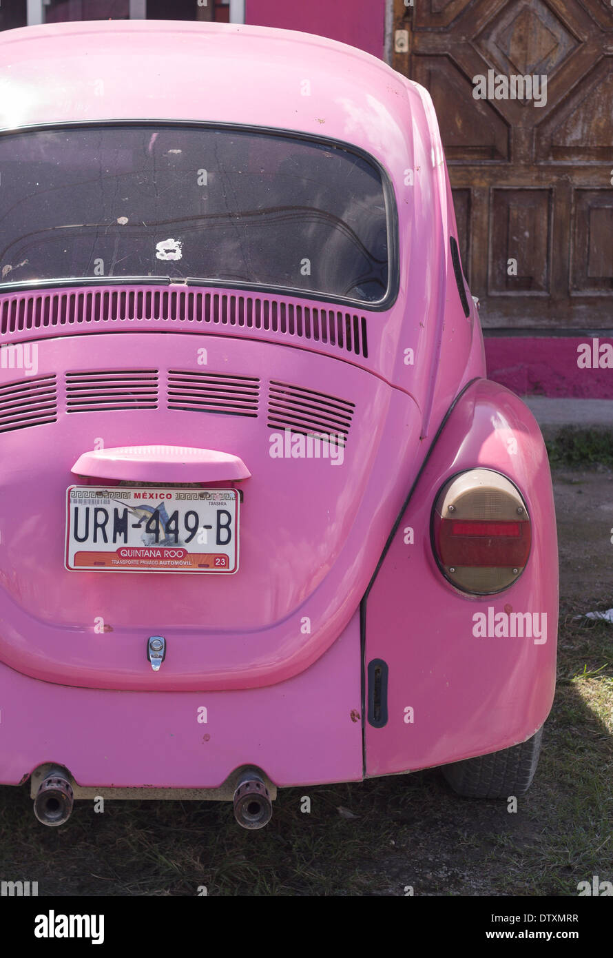 Pink VW Beetle. A bright pink volkswagon beetle parked in front of a pink house. Tulum, Quintana Roo, Mexico Stock Photo