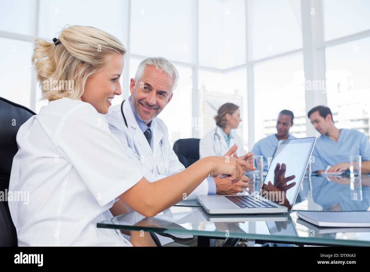 Two smiling doctors looking at a laptop Stock Photo