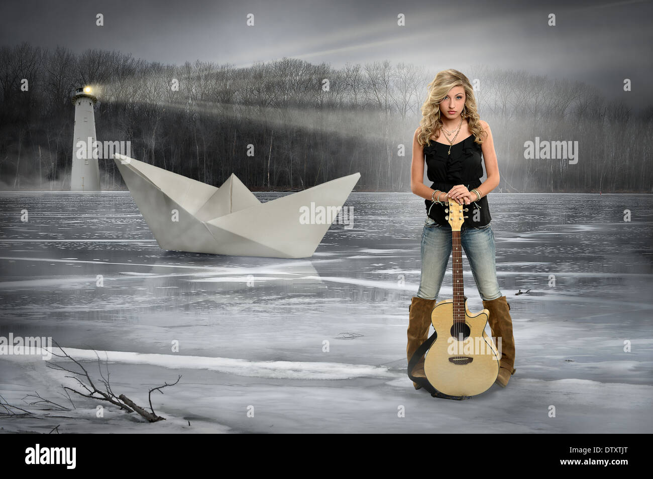 Young teen girl holding guitar standing on frozen lake Stock Photo