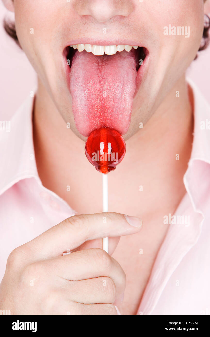 Caucasian man licking lollipop Stock Photo