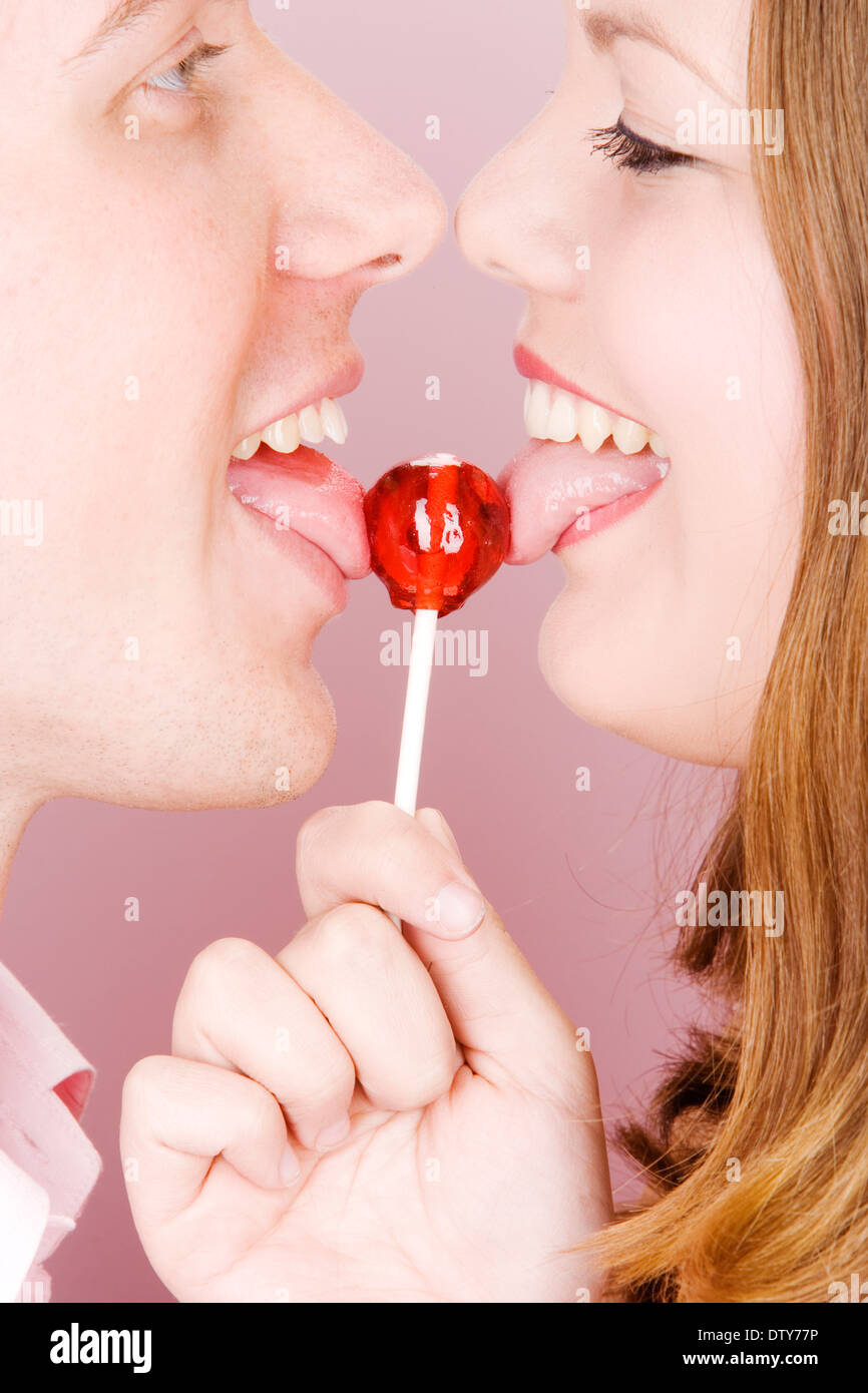 Caucasian couple licking lollipop Stock Photo