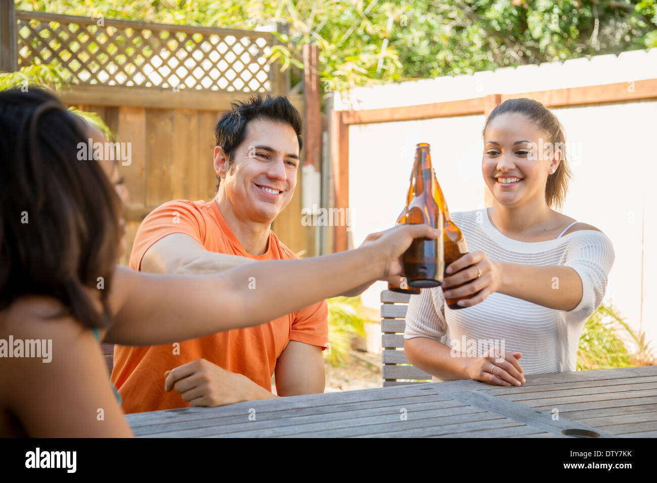 Friends toasting each other in backyard Stock Photo
