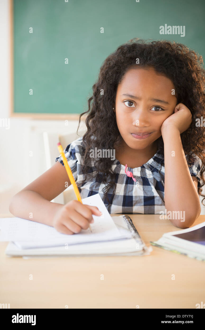 Mixed race student working in classroom Stock Photo