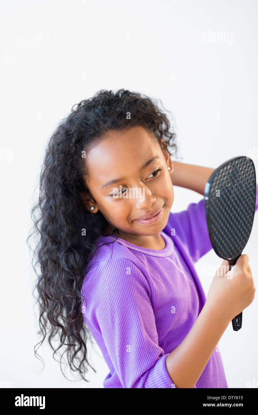 Mixed race girl admiring herself in mirror Stock Photo