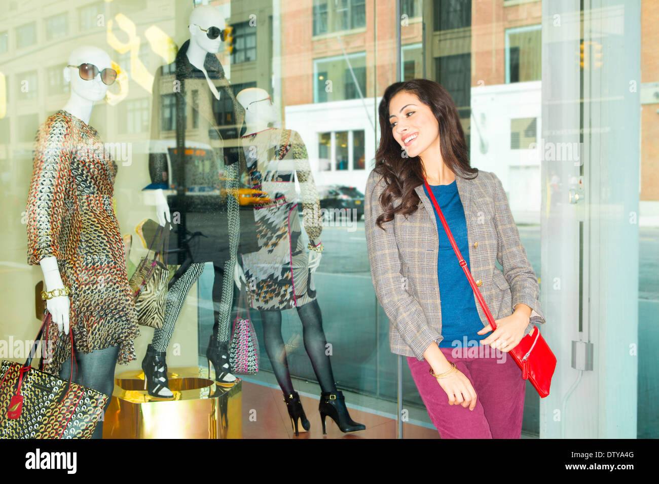 Mixed race woman window shopping in city Stock Photo