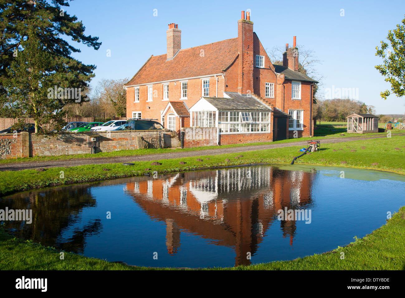 Traditional red brick farmhouse and farmyard water pond, Lux Farm
